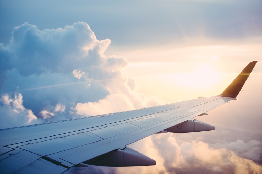 Aircraft wing above the clouds en route to a Bali airport transfer